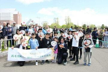 故郷・幕別町でのパレードで、子供たちと写真に収まる高木美帆さん（幕別町提供）