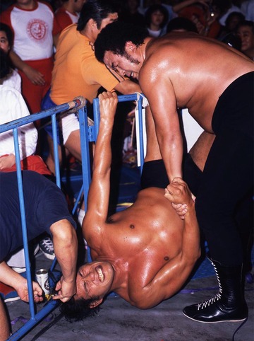 場外フェンスに逆さ吊りにされ髪の毛を切られた猪木（１９８２年９月、大阪）