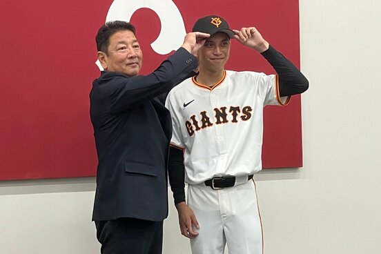 入団会見を行った黄錦豪投手。左は吉村編成本部長