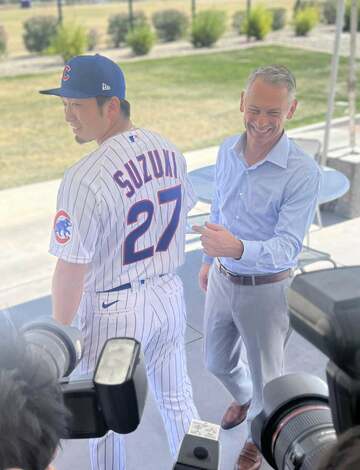  「２７」が光る鈴木（左）のユニホーム姿を笑顔で披露するホイヤー編成部長（東スポWeb）