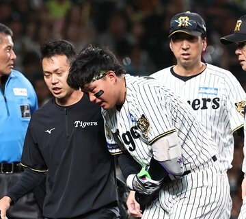 ７回に死球を受けて顔面蒼白の森下翔太(中)を、心配そうに見守る藤川監督(右)