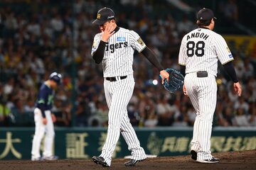 ８回に逆転を許し、うつむきながらマウンドを降りる阪神・岩崎優(左)