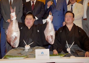 祝勝会で鯛を持ち上げる大の里。右は二所ノ関親方
