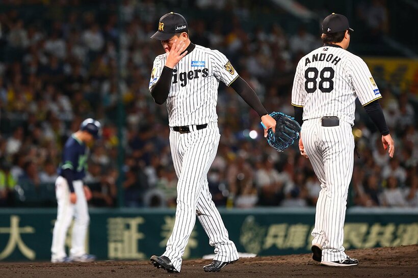 ８回に逆転を許し、うつむきながらマウンドを降りる阪神・岩崎優(左)