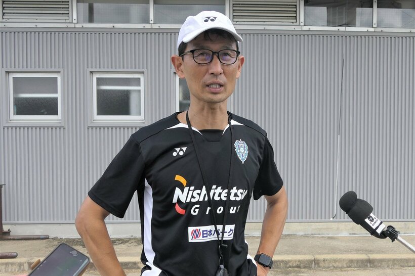 囲み取材に応じる金明輝監督
