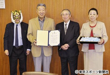  新間氏（左）は虎のマスクをかぶって感謝状の贈呈式に出席