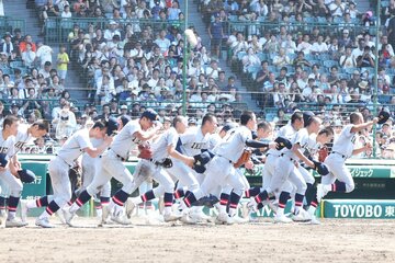 試合に勝利しスタンドに向かって駆け出す仙台育英ナイン
