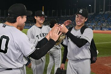 投手陣に労われながら引き上げる巨人・西舘(右)