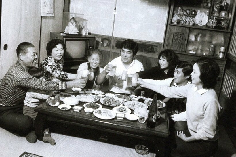 大学時代に実家で食事をする谷津嘉章（左から４人目・本人提供）