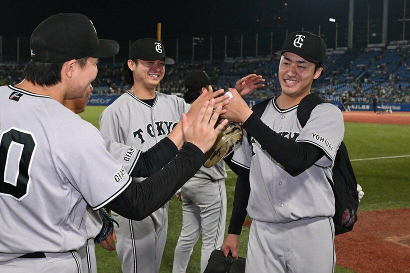 投手陣に労われながら引き上げる巨人・西舘（右）
