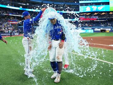 大量の水をかけられ祝福される岡本和真（ロイター）