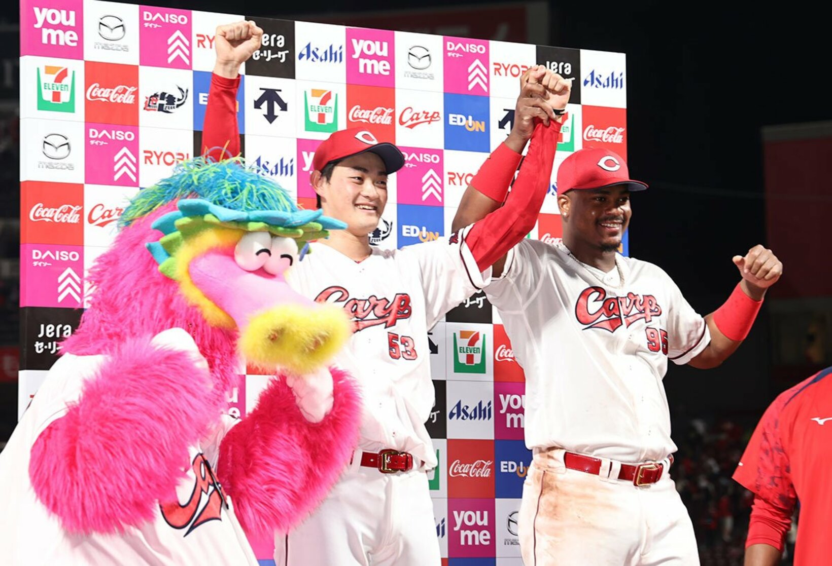 お立ち台で勝利投手になったルーキー・岡本駿(中)を称える広島・モンテロ