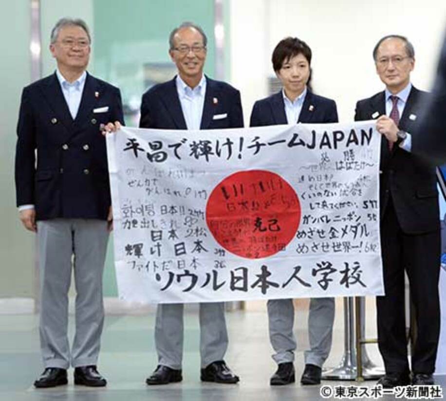  日の丸を持つ小平奈緒主将（右から2人目）ら日本選手団