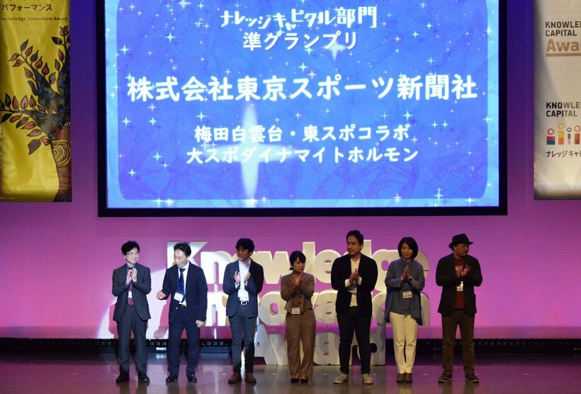 準グランプリ発表で、ピンスポットを浴びる呉龍一・株式会社梅田白雲台代表取締役社長(左から２人目)