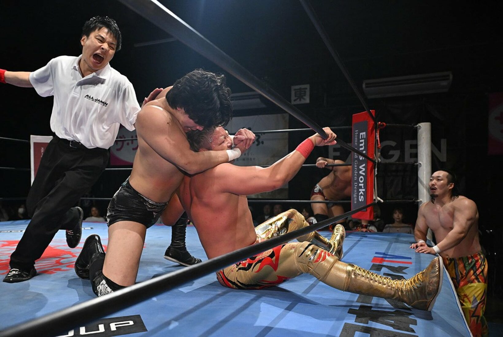 レフェリーの制止を無視して、宮原健斗(中央右)をフェイスロックで絞る安齊勇馬