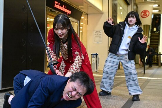 新宿高島屋前で甲田代表を襲撃する上坂すみれ（中)と襲撃に驚く神嵜志音（右）