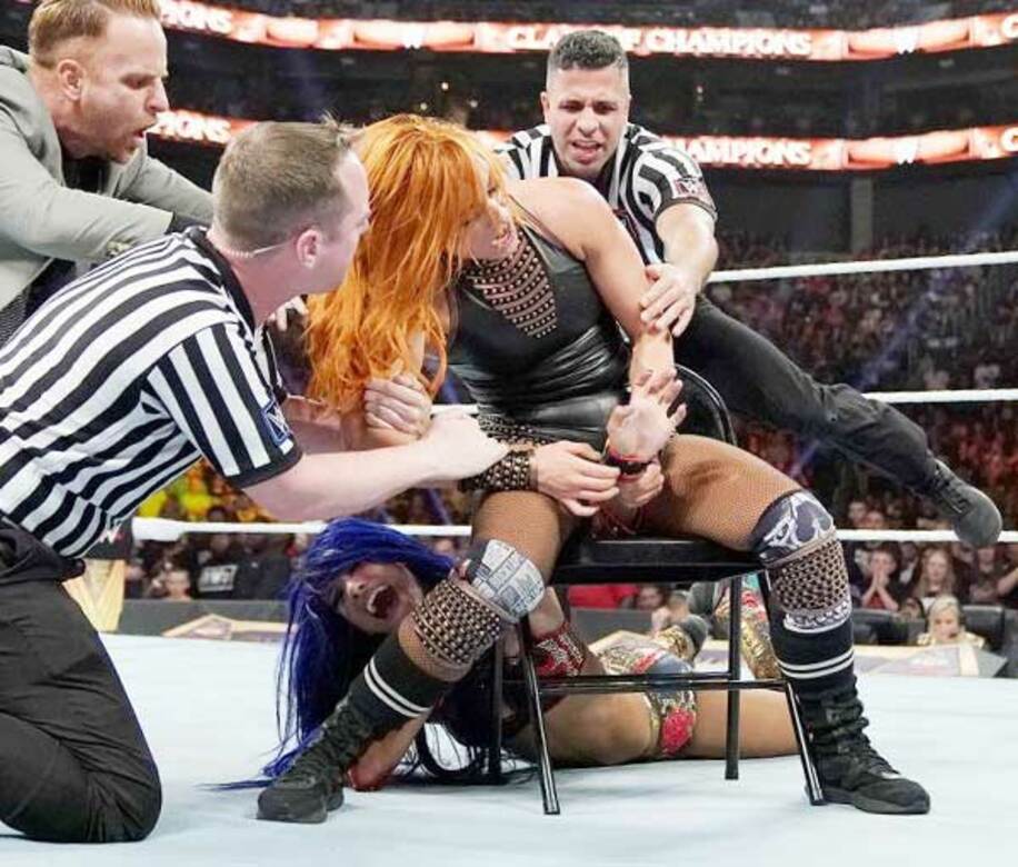  サーシャ・バンクス（下）にイスを使ったディスアーマーを決めるベッキー・リンチをレフェリーとスタッフが制止した（Ｃ）2019 WWE, Inc. All Rights Reserved.