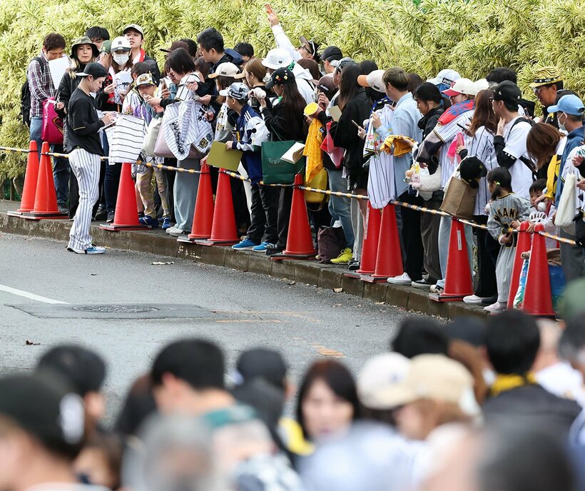 サインする阪神・中野拓夢(左奥)に長蛇の列が