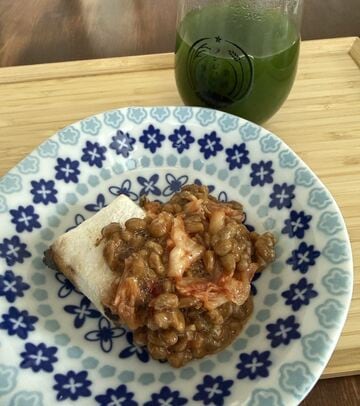 納豆とキムチを乗せた餠。合わせて飲むなら焼酎の青汁割りを！