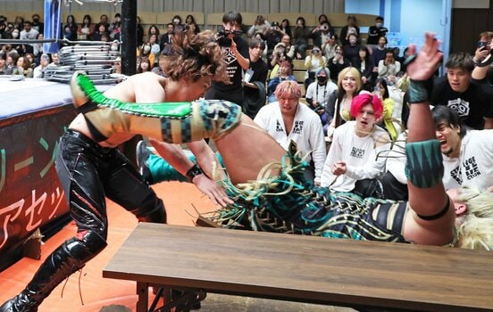 納谷（右）を場外のテーブルに叩きつけ勝利した岡谷