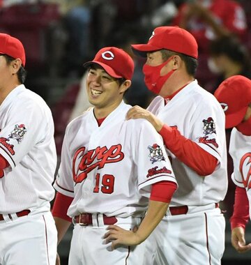  佐々岡監督に肩をもまれ笑顔の野村