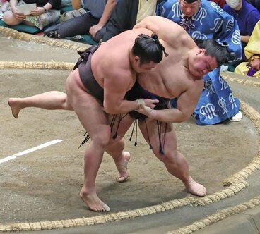 土俵際で義ノ富士(右)の投げに屈した霧島