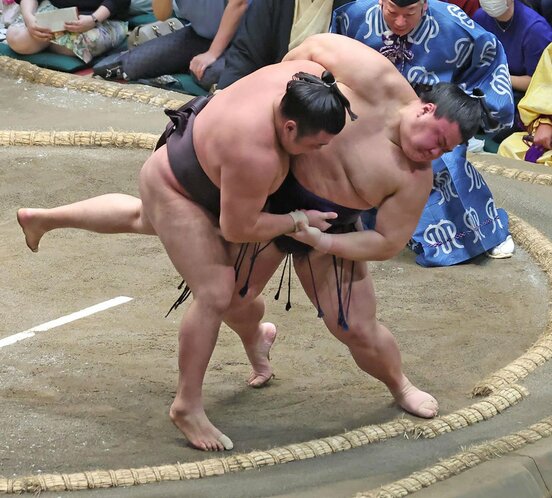 土俵際で義ノ富士(右)の投げに屈した霧島