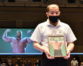  アニマル・ウォリアーさんの遺影を持つ和田京平レフェリー