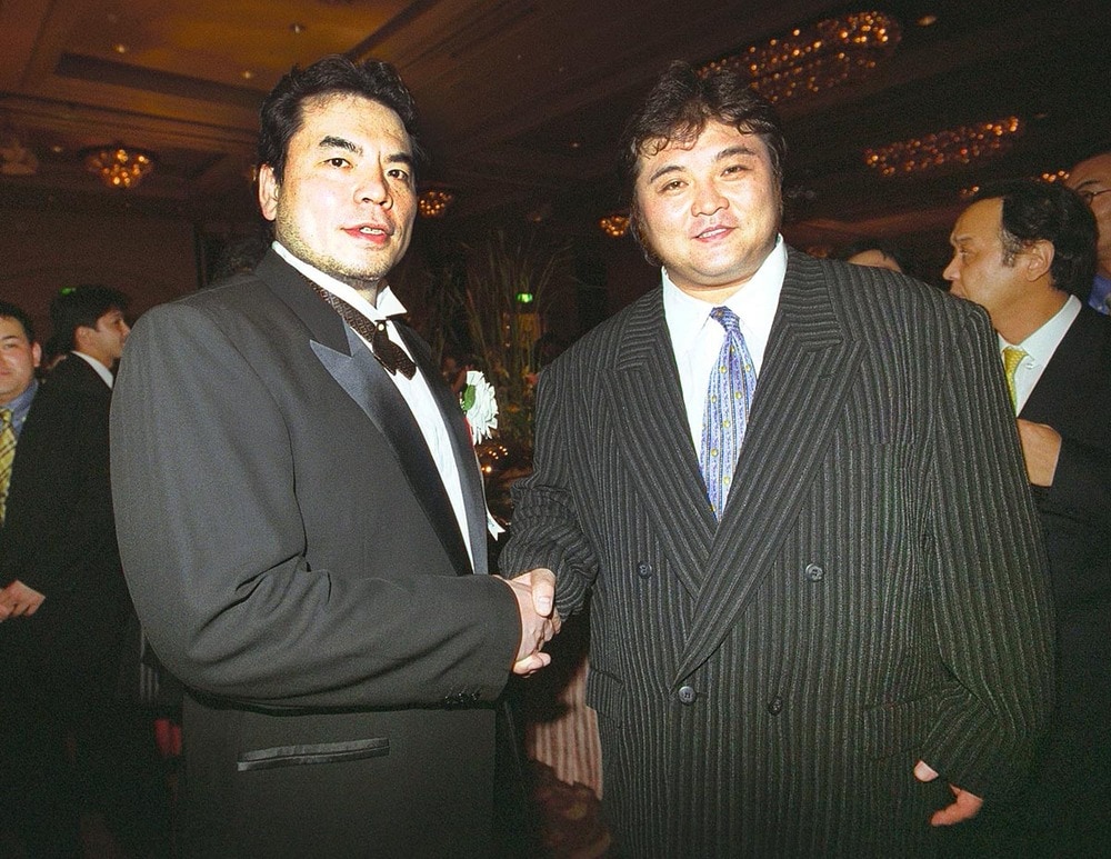 ノアの1周年パーティーでにこやかに握手を交わす三沢(左)と橋本(2001年8月、恵比寿のウェスティンホテル)