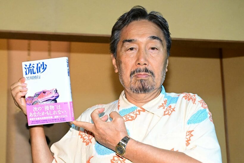 新刊を持つ黒川博行氏