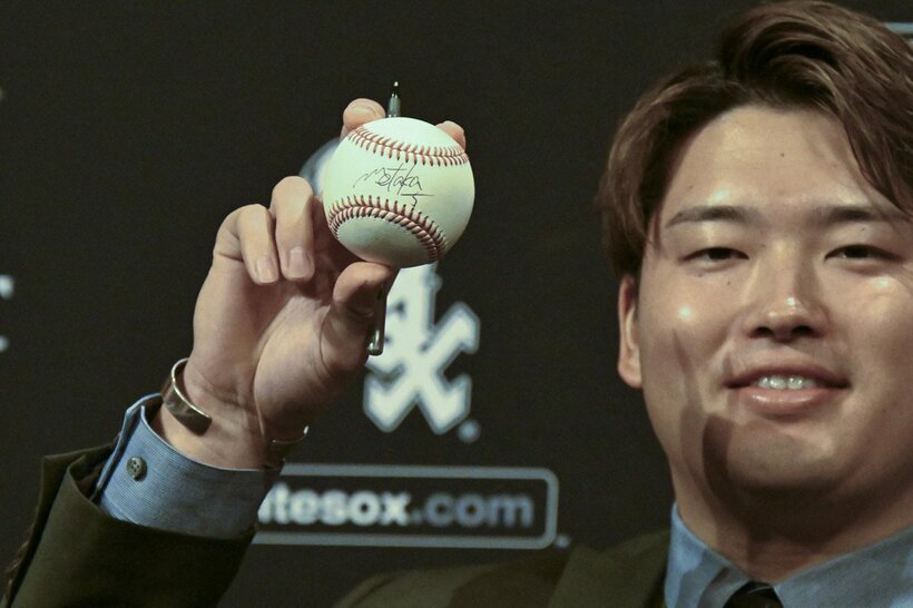 サインボールを手に笑顔を見せる村上（ロイター）