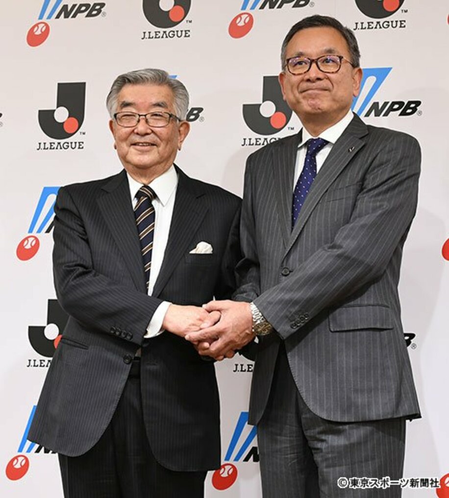  握手する斉藤コミッショナー（左）と村井チェアマン