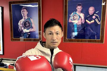 グローブを着けポーズを取る越本隆志さん