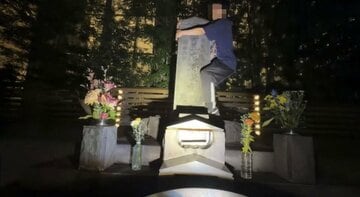 将門塚によじ登る男性配信者