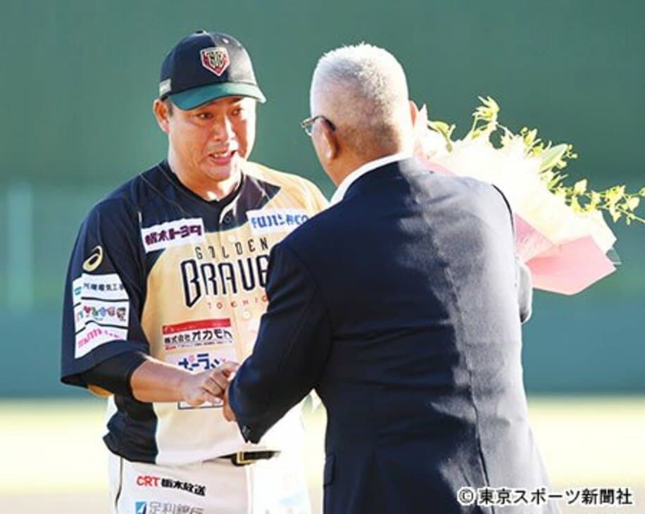 試合後のセレモニーで大矢氏（右）から花束を贈られた村田