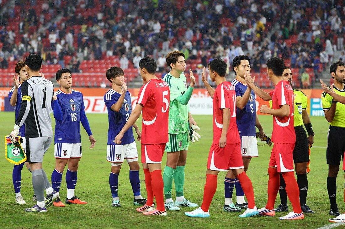 開始前、日本代表(奥)ともハイタッチする北朝鮮代表イレブン