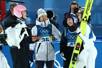 高梨沙羅(左から３人目)ら日本勢に笑顔で出迎えられた丸山希(右)