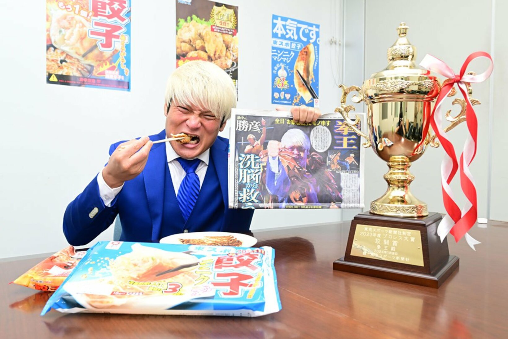 〝プロレス大賞敢闘賞〟に選ばれ、東スポ餃子を頬張る拳王（２０２４年）
