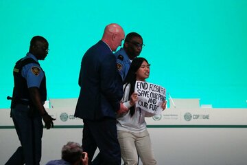 警備員に連れ出されるカングジャムさん（ロイター）