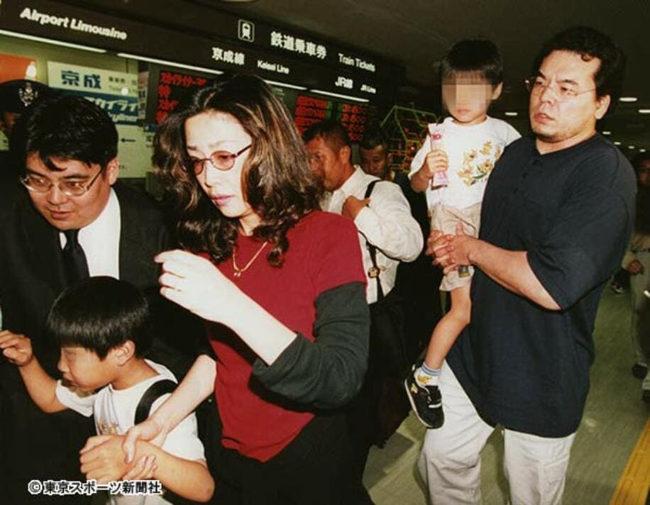  成田空港で鶴田さんの遺体を出迎えた三沢（右）が、保子夫人らをガードした