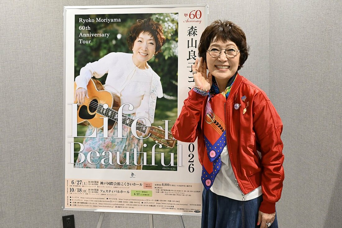 ポスターの前でポーズをとる森山良子