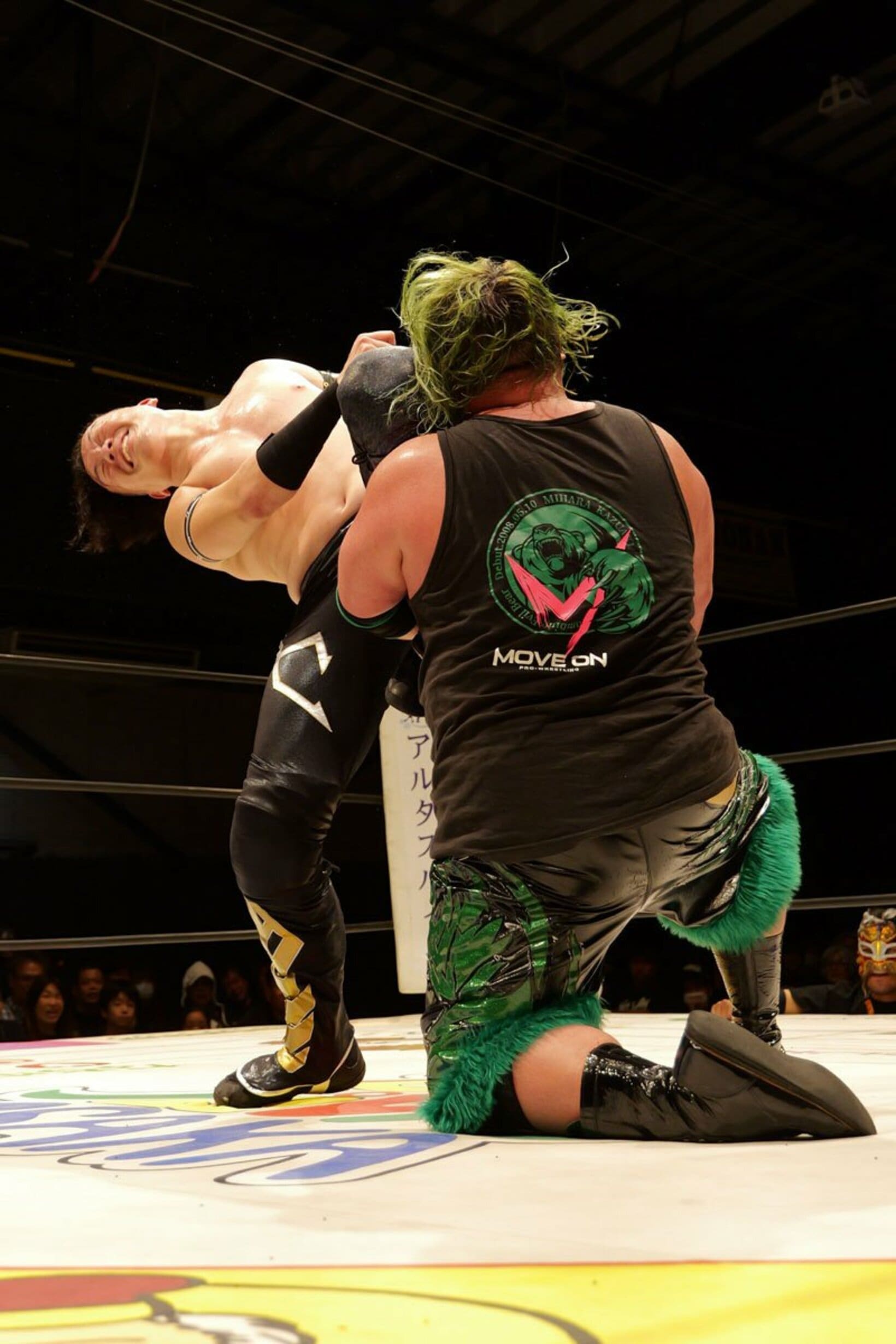 三原一晃(手前)の顔面にヒザを叩き込む松房龍哉