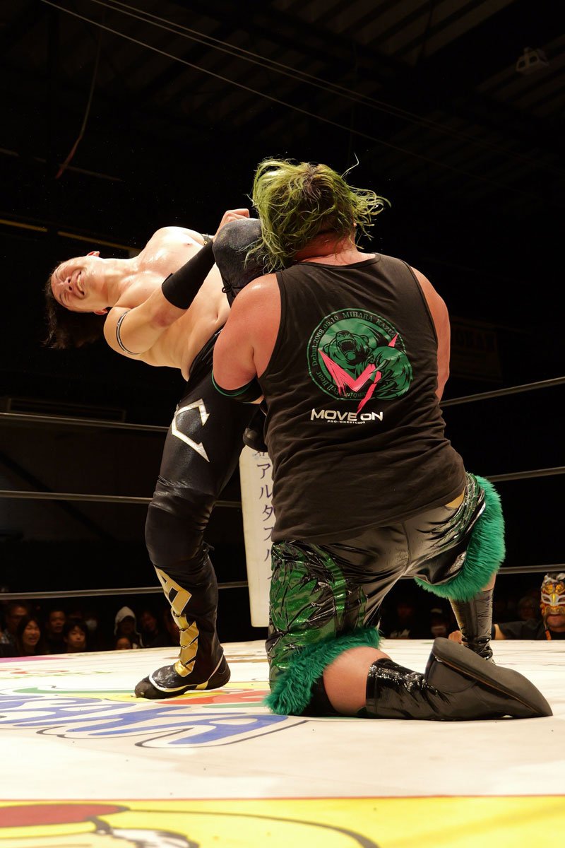 三原一晃(手前)の顔面にヒザを叩き込む松房龍哉