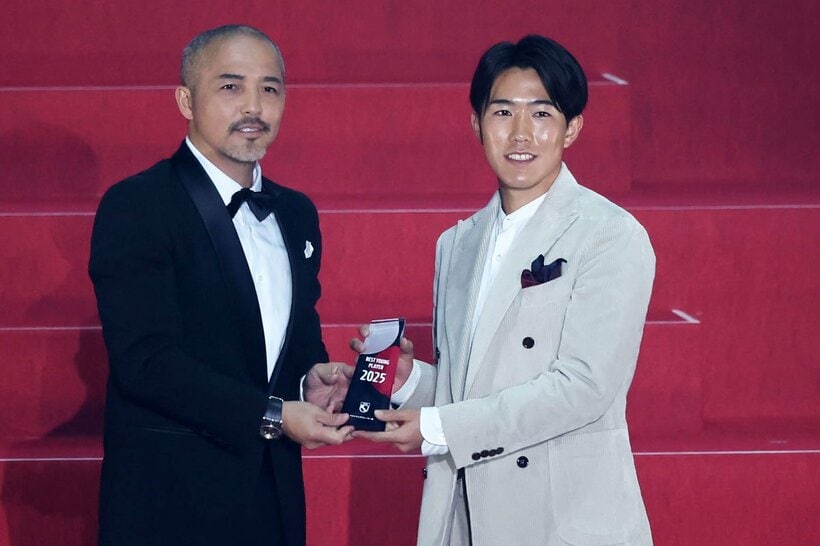 プレゼンターの小野伸二（左）からトロフィーを受け取る佐藤龍之介