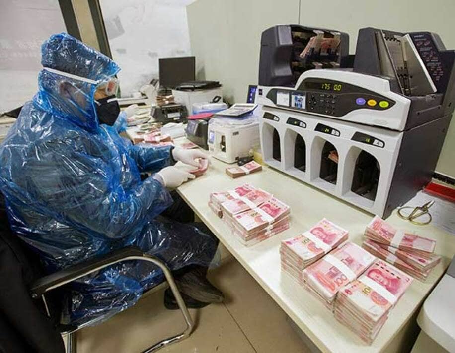  中国山西省で紙幣を消毒する銀行員（ロイター）
