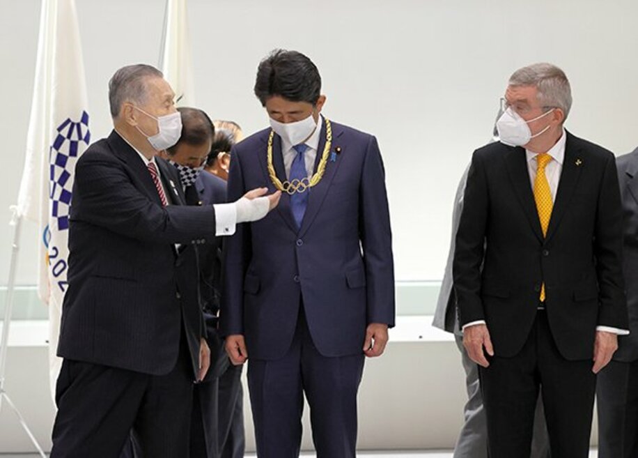 安倍前首相に授与された「五輪オーダー」を見つめる東京五輪・パラリンピック組織委の森会長。右はＩＯＣ・バッハ会長(代表撮影)