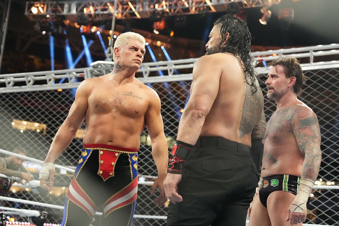 CMパンク(右)の前でにらみ合うローマン・レインズ(中)とコーディ・ローデス（©WWE）