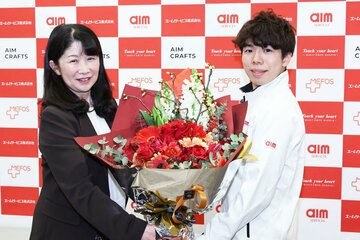 管理栄養士の西山英子氏(左)から花束を贈呈される佐藤駿