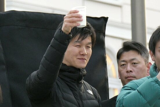 応援演説で牛乳を飲む鈴木憲和氏