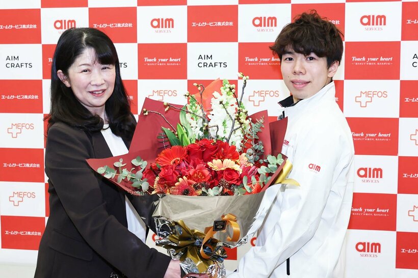 管理栄養士の西山英子氏(左)から花束を贈呈される佐藤駿